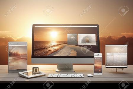 Computer, smart phone and tablet pc on wooden table with sunset background