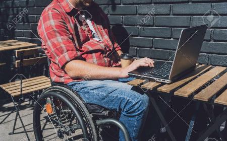 Web accessibility example of a Freelancer with a physical disability who uses wheelchair working at the street cafe 